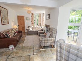 A living room with a sofa and armchairs at The Old Post House at Low Stott Park near Newby Bridge