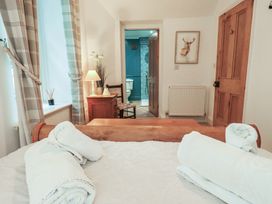 A bedroom with a bed and wooden furniture at The Old Post House at Low Stott Park near Newby Bridge