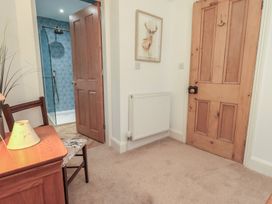 A hallway with a door and radiator at The Old Post House at Low Stott Park