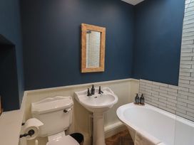 A bathroom with a toilet, sink, and bathtub at The Old Post House at Low Stott Park near Newby Bridge