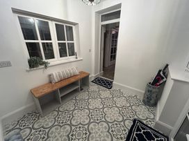 A hallway with a bench and patterned floor tiles at The Old Post House at Low Stott Park