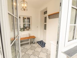 An entrance hall with a bench and coat hooks at The Old Post House at Low Stott Park