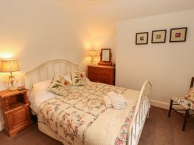 A bedroom with a bed and nightstand at The Old Post House at Low Stott Park near Newby Bridge