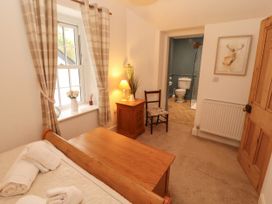 A bedroom with a bed and lamp at The Old Post House at Low Stott Park near Newby Bridge