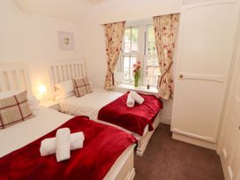 A bedroom with two beds and a window at The Old Post House at Low Stott Park near Newby Bridge