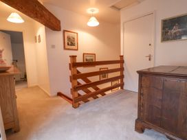 A hallway with carpet floor wooden railing and furniture at The Cottage Halkyn near Holywell