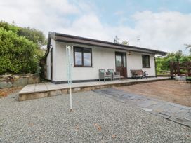 A single-story house with a gravel driveway and outdoor seating at Y Stabal in Llanddoged near Llanrwst
