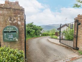 A driveway entrance with a gate and a postbox on a brick wall at Y Stabal in Llanddoged near Llanrwst