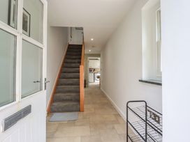 A hallway with stairs and a washing machine at 15 Boscaswell Downs Pendeen