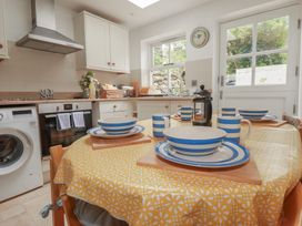 A kitchen with dining table and cooking appliances at 15 Boscaswell Downs in Pendeen