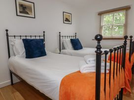 A bedroom with two beds and wall art at 15 Boscaswell Downs in Pendeen