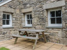 An outdoor area with a stone wall and a picnic table at 15 Boscaswell Downs Pendeen