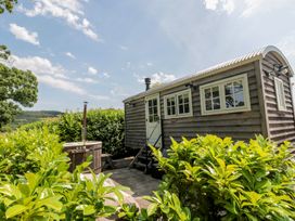 A wooden cabin with a hot tub and steps at Acorn in Bleadon