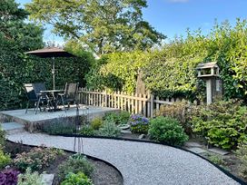A garden with seating area and path at Curlew Cottage at Hawkshead