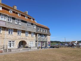 A building with outdoor seating and signage at The Bay House