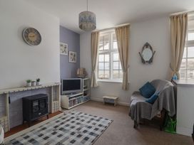 A living room with a sofa and television in Flat F