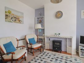 A living room with chairs and a television at Flat F