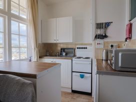 A kitchen with a sink stove and microwave at Flat F 