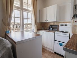 A kitchen with cabinets and a stove at Flat F