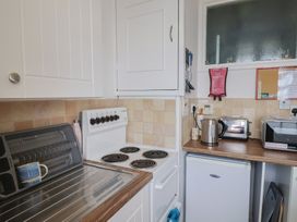 A kitchen with stove and appliances at Flat F 
