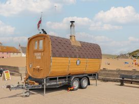 A sauna on wheels at the beach with a trailer at Flat F in 