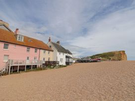 A beach with colorful houses and a cliff at Flat F in 