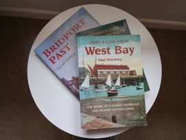 Three books on a table at Flat F Bay House in West Bay