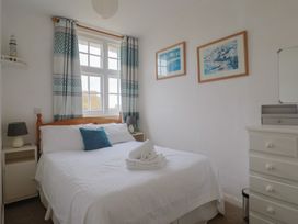 A bedroom with a bed and curtains at Flat F Bay House West Bay