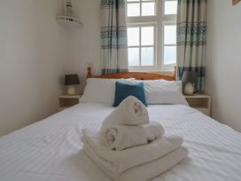A bedroom with a bed and towels at Flat F Bay House in West Bay