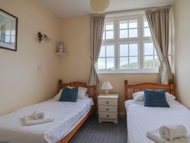 A bedroom with two single beds and a nightstand at Flat F Bay House West Bay