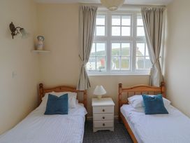 A bedroom with two single beds and a window at Flat F Bay House in West Bay