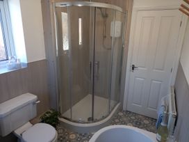 A bathroom with a shower and toilet at Postman's Cottage in Bridlington