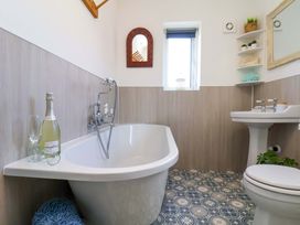 A bathroom with a bathtub and sink at Postman's Cottage in Bridlington