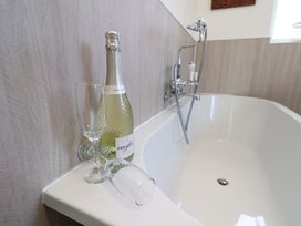 A bathroom with champagne and glasses at Postman's Cottage in Bridlington
