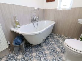 A bathroom with a bathtub and toilet at Postman's Cottage in Bridlington