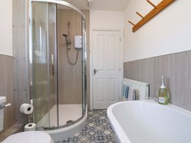 A bathroom with a shower and bathtub at Postman's Cottage in Bridlington