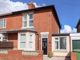 A two-story brick house with windows and door at Lobster Pot Retreat in Newbiggin-By-The-Sea
