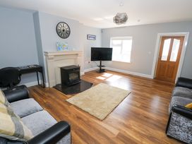 A living room with a television and fireplace at Tí Tom Nárta, Trabane near Lettermore, County Galway
