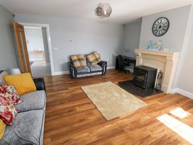 A living room with a sofa and an armchair at Tí Tom Nárta Trabane near Lettermore, County Galway