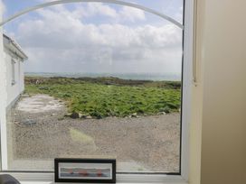 A view through a window showing grass and sea at Tí Tom Nárta, Trabane near Lettermore, County Galway