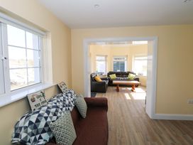 A living room with furniture and windows at Tí Tom Nárta in Trabane near Lettermore, County Galway