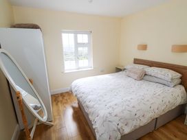 A bedroom with a bed and wardrobe at Tí Tom Nárta, Trabane near Lettermore, County Galway