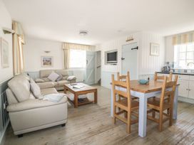 A living room with a sofa table and chairs at Owls Roost in Gorran Haven