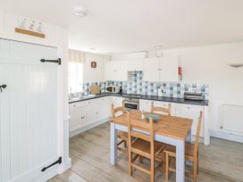 A kitchen with a table and chairs at Owls Roost in Gorran Haven