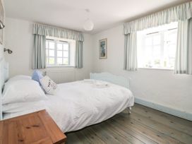 A bedroom with a bed and bedside table at Owls Roost in Gorran Haven