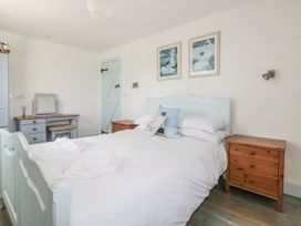 A bedroom with a bed and bedside tables at Owls Roost in Gorran Haven