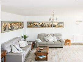 A living room with sofas and artwork on the wall at Squirrels Dray in Gorran Haven