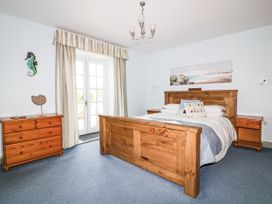 A bedroom with a bed and dressers at Squirrels Dray in Gorran Haven