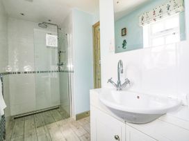 A bathroom with shower and washbasin at Squirrels Dray in Gorran Haven