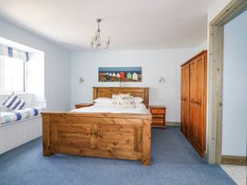 A bedroom with a bed and a wardrobe at Squirrels Dray in Gorran Haven